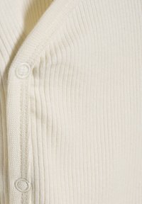 Crème geribde cardigan met een zachte textuur, voorzien van een eenvoudige knoopsluiting en een V-hals ontwerp.