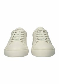 Cream-colored sneakers with a smooth leather upper, rounded toe, and flat rubber sole. Features minimalistic lacing and subtle branding.