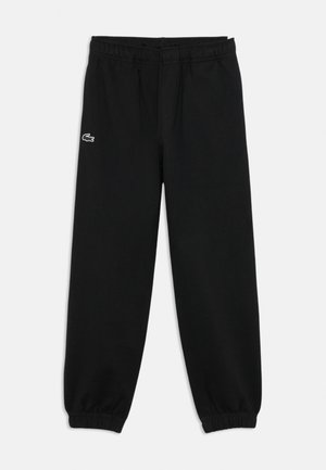 Sorte elastiske sweatpants med elastik i taljen og manchetter med et lille hvidt og sort krokodillelogo på venstre lår.