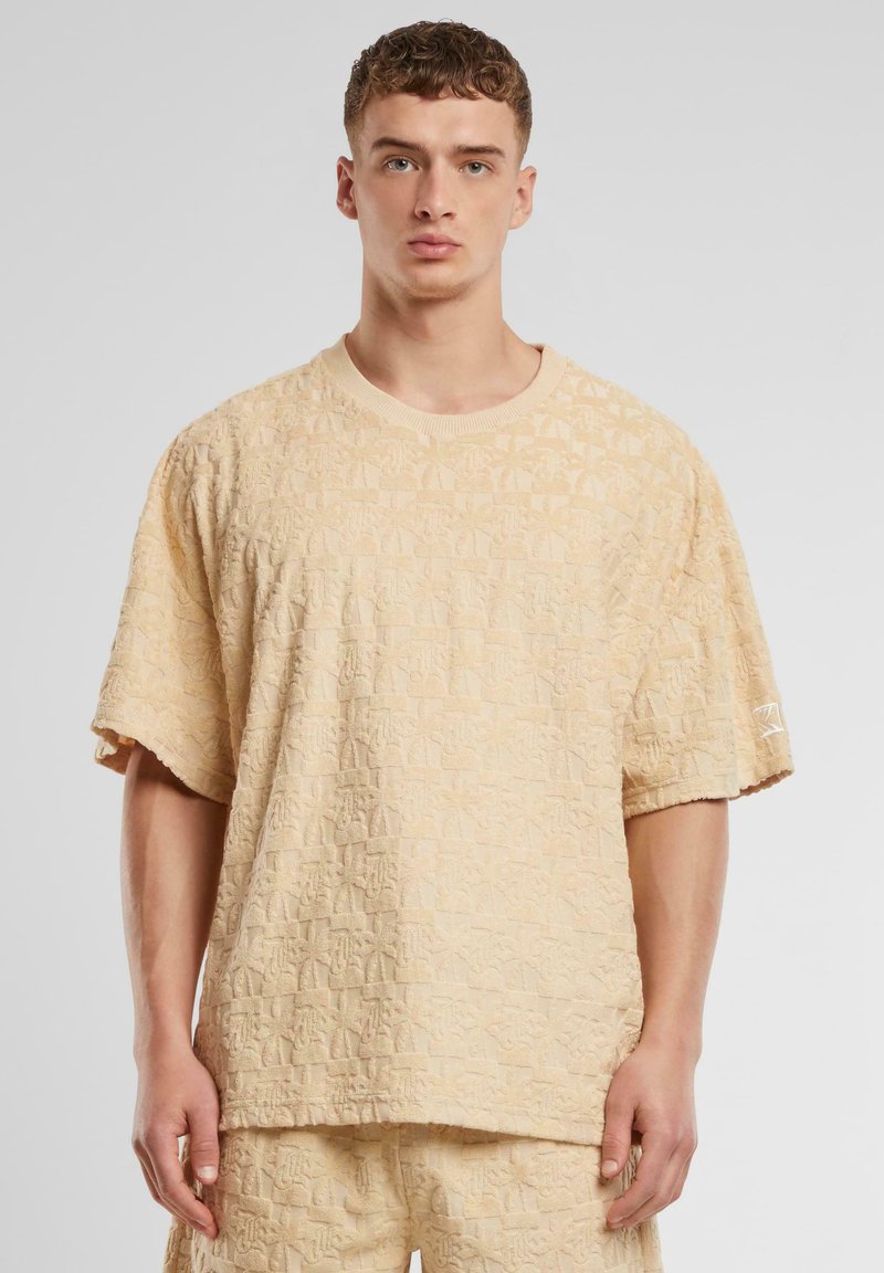Beige strukturované tričko s krátkým rukávem s embosovaným vzorem, kulatým výstřihem a malým logem na rukávu. Zaoblený design spodního lemu.