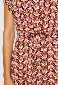 Floral-printed dress with a pinkish-brown background, featuring a black outline pattern and a tie detail at the waist. Short sleeves.