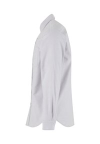 Chemise blanche à manches longues vue de profil droit, avec un poignet boutonné et une poche poitrine avant visible.