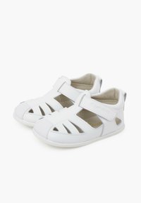 Sandali bianchi con design traforato, cinturino in velcro e suola in gomma. Caratterizzati da una tomaia in pelle liscia e un'imbottitura morbida per il massimo comfort.