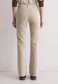 Beige corduroy broek met een recht gesneden pijp, twee achterzakken en een soepele textuur. Hoge taille met zichtbare stiksels.