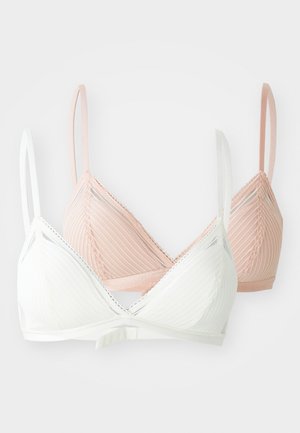 Dve bezdrôtové podprsenky: jedna biela, druhá ružová. Obe majú rebrovanú látku, tenké ramienka a zúbkované okraje pozdĺž výstrihu.