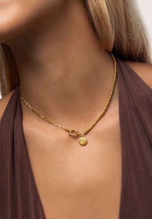 Collana d'oro con una combinazione di sezioni a catena a pallini e catena collegata, con un pendente circolare che mostra un design impresso.
