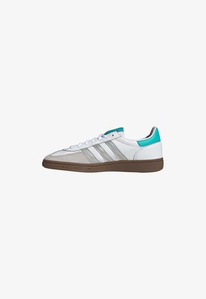 White athletic sneaker with turquoise accents, three silver stripes, and a textured brown rubber sole. Features flat white shoelaces.