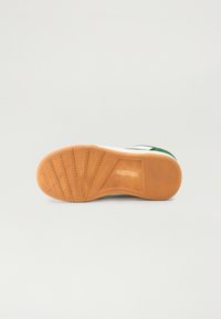Sola de sapatilhas com uma sola de borracha natural, apresentando um padrão de piso texturizado e um logótipo da marca visível embutido na lateral.