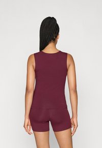 Μαρούλι κορμάκι και σορτσάκι από ελαστικό ύφασμα. Το κορμάκι έχει στρογγυλή λαιμόκοψη και το σορτσάκι είναι εφαρμοστό, προσφέροντας και τα δύο έναν απλό σχεδιασμό.