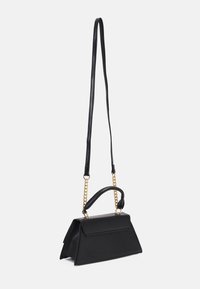 Black structured handbag with a folded design, leather material, gold chain accents, and a detachable strap. Features a top handle and flap closure.