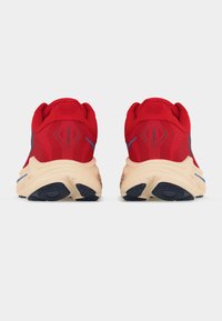 Κόκκινα αθλητικά παπούτσια με μπεζ σόλες και μαύρη πέλμα, εμφανιζόμενα από πίσω σε λευκό φόντο, με το κείμενο "CLIFTON 10" στη φτέρνα.