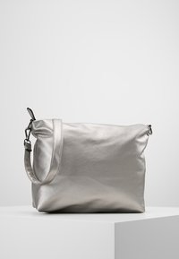 Borsa a tracolla in metallo argento con una texture liscia, tracolla regolabile e design morbido e informale. Presenta dettagli hardware minimi.