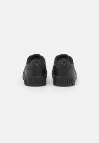 Zapatillas negras con parte superior de cuero texturizado, cuello acolchado y suela de goma con ranuras verticales; logotipo en el talón.