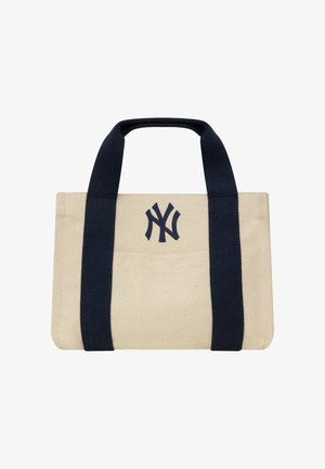 Petit sac cabas en toile beige avec de larges anses noires et un logo noir des New York Yankees sur la poche avant.