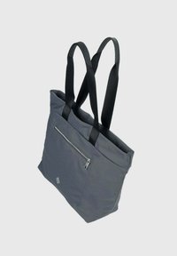 Sac en toile gris avec des poignées en sangle noire, doté d'une poche zippée sur un côté et d'une texture douce et lisse.