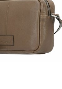 Borsa in pelle marrone con forma rettangolare, superficie testurizzata e zip argentata. Presenta un piccolo etichetta del marchio cucita su un lato.