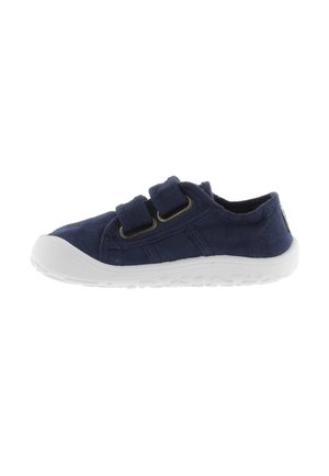 Zapatillas de lona marinas con dos correas de Velcro, suela de goma blanca, parte superior texturizada y acentos circulares en el talón y los laterales.