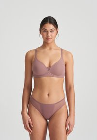 Mauve wireless underwire bra with adjustable straps, smooth texture, and matching low-rise brief displaying a seamless design.