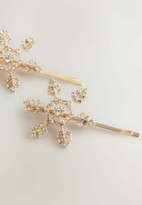 Gul snöflinga hårnål med intrikata bladdesigns prydda med klara rhinestones, med en slät yta och glänsande finish.