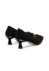 Black suede pumps with a low, flared heel and decorative beaded accents on the toe. Smooth texture and pointed toe design.