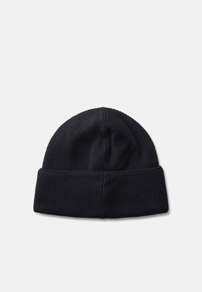 Gorro de malha preto com textura canelada e bainha dobrada. Parte superior redonda sem logótipos ou embellishments visíveis.