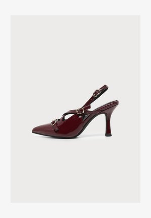 Scarpa slingback in vernice bordeaux con tacco alto, punta affilata e tre fibbie dorate su sfondo bianco.