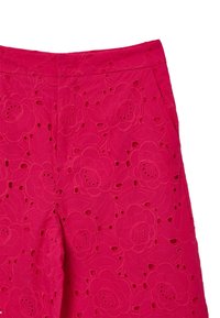 Rosa bestickte Hose mit floralem Muster und Ausschnitten. Der Stoff hat eine strukturierte Optik und verfügt über zwei seitliche Taschen.