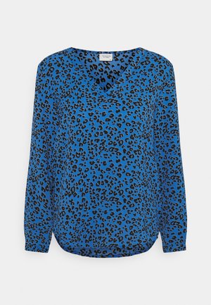 Blouse bleue à manches longues avec col en V, motif léopard irrégulier noir et ourlet légèrement arrondi.
