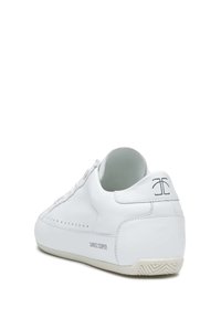 Sneaker bianche in pelle con profilo basso, forma arrotondata, dettagli perforati e marchio discreto sul tallone. Suola in gomma con texture.
