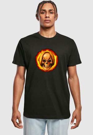 Sort bomulds T-shirt med et livligt kranietryk omgivet af orange flammer, der fremhæver kraftige farver og detaljeret design.