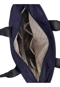 Dunkelblaue Canvas-Tasche mit einem Reißverschlussöffnen, ausgestattet mit einem beigen Innenfutter, das bedruckte Muster aufweist, und mehreren Innenfächern zur Organisation.