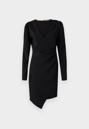 Un vestido negro de manga larga, con escote en V y un frente drapeado. Presenta un escote decorativo en tono dorado y un dobladillo asimétrico.