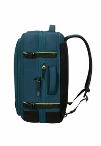 Turkos ryggsäck med en texturerad tyg, två framzipplade fack, justerbara meshremmar och svarta detaljer med gula accents.