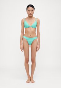 Turkos ribbat bikini-set som har ett triangeltopp och lågrisk nederdel, båda med justerbara band och slät yta.