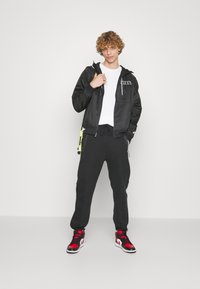 Nike Sportswear TECH FLEECE OPEN HEM PANT - Träningsbyxor - black
