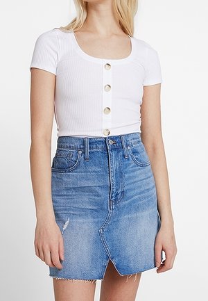 Witte geribde korte mouw top met een ronde hals en zesknopen sluiting aan de voorkant. Gepaard met een lichtblauwe spijkerrok met een onafgewerkte zoom en een opening aan de voorkant.