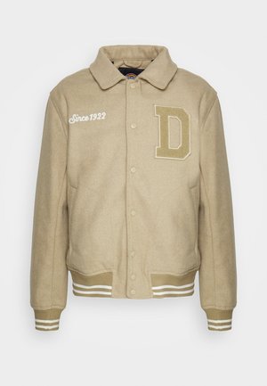 Bežinis vilnonis švarkas su apykakle, spaudėmis, dideliu "D" pleistru ir baltais juostuotais elastiniais rankogaliais bei apatine dalimi.