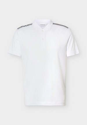 Λευκό πόλο μπλουζάκι με κοντά μανίκια, με δύο κουμπιά στο κολάρο και μαύρες ρίγες κατά μήκος των ραφών στους ώμους.