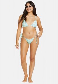 Miętowo-zielony dwuczęściowy bikini z trójkątnym topem i spodenkami z wiązaniem po bokach, ozdobione kwiatowym wzorem. Gładka faktura i regulowane paski.