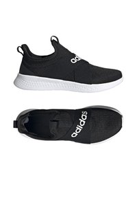 Černé sportovní boty s texturovaným pleteným svrškem, elastickým páskem a bílou podrážkou. Na pásku se nachází výrazné bílé logo.