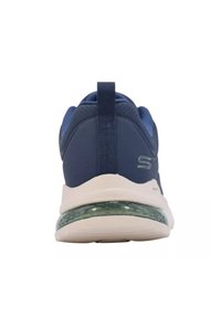 Scarpe sportive blu navy con colletto imbottito, tallone strutturato e un dettaglio di ammortizzazione verde trasparente sulla suola bianca.