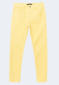 Pantalones vaqueros skinny amarillos de mezclilla con cinco bolsillos, cierre de botón en la parte delantera y diseño de corazón bordado en la cadera derecha.