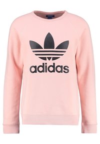 Ljusrosa Adidas-tröja med långa ärmar, svart trefoil-logotyp och texten "adidas" centrerad på framsidan.