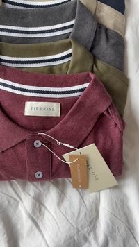 Patru cămăși polo în culorile roșu, măsliniu, gri și bej, având guler cu dungi, butoane și etichete de marcă. Material moale cu o croială casual.