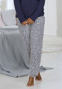 Jūras spēku garām piedurknēm krekls ar baltiem pidžamas biksēm ar punktu rakstu. Bikses ir ar elastīgu jostasvietu un sasietām potītēm. Mīksta auduma tekstūra.