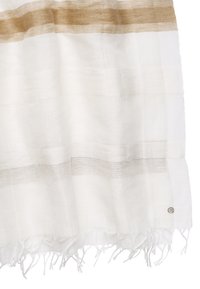 Écharpe blanche à rayures horizontales beiges avec extrémités à franges, ornée d'une petite étiquette logo métallique ronde sur le bord inférieur.