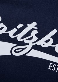 Navyblaues Gewebe mit großen weißen kursiven Texten, die das Wort "Spitz" zeigen, und einer unterstrichenen Grafik. Weiche Textur mit einem lässigen Design.