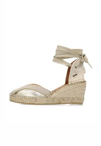 Scarpa wedge in tessuto beige con punta metallica, tacco intrecciato e morbida fascia alla caviglia. Presenta una suola avvolta in iuta.