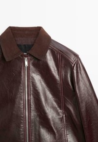 Giacca in pelle bordeaux con finitura liscia, caratterizzata da un colletto in camoscio marrone e una cerniera argentata. Include cuciture dettagliate e spalle strutturate.