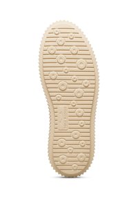 Sole of a shoe, beige rubber material with circular and oval treads, textured surface, featuring a distinctive brand logo in the center.